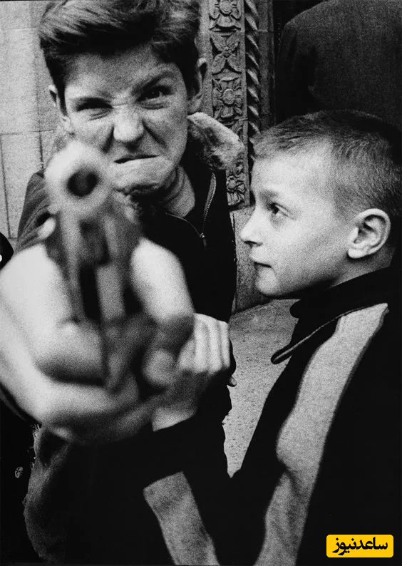 ویلیام کلاین (William Klein) عکاس ساکن نیویورک توانسته است یکی از قوی‌ترین حالت‌های چهره سوژه را در اثر خود به تصویر بکشد. در روبه‌روی او پسری با یک تفنگ در دست ایستاده؛ درحالی که فرد کنار او با نگاهی کاملا بی‌تفاوت یک کنتراست شدید را ایجاد کرده است.