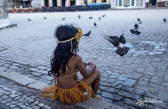 یک معترض کودک در حال تماشای کبوترها در شهر مانائوس برزیل است. مردم بومی به لایحه ای اعتراض کردند که در کنگره در حال بررسی است و می تواند مرزبندی سرزمین های بومیان را دشوار کند./EPA