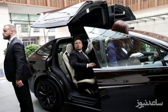 ایلان ماسک مدیر عامل تسلا سوار بر یک خودروی تسلا در مقابل هتلی در شهر پکن/ رویترز