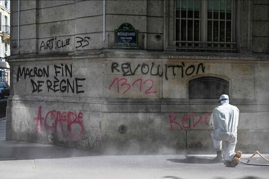 کارگر شهرداری پاریس در حال پاک کردن شعارهای ضد ماکرون (رییس جمهوری فرانسه) از روی ساختمان ها یک روز پس از تظاهرات گسترده در روز جهانی کارگر/ خبرگزاری فرانسه