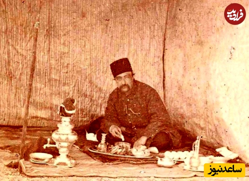  ناصرالدین شاه در حال صرف آبگوشت در چادری که در یک محوطۀ جنگلی برپا شده است؛ سماور زغالی نیز در  کنار بساط غذا دیده می‌شود.