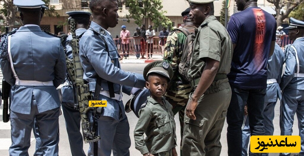 پسر کوچکی که یونیفورم نظامی پوشیده است.