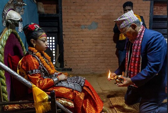 شهردار شهر "پاتان" نپال در حال اجرای مراسم آیینی در کنار یک الهه زنده (کوماری). الهه‌های زنده دخترانی هستند که در سنین قبل از بلوغ بوده و تجسم الهه قدرت هندو (کالی) به حساب می‌آیند. آنها توسط هندوها و بودایی ها پرستش می شوند./ EPA