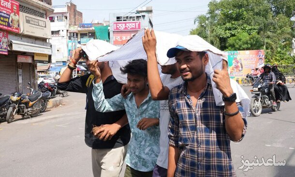 جوانان هندی برای ایمن ماندن از آفتاب گرم تابستانی پارچه سفید روی سر خود کشیده اند./ آسوشیتدپرس