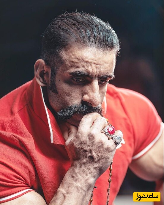 فیگور جذاب و هوش پران هادی چوپان با گوشی آیفون مقابل کتابخونه شخصی/ دکور ایرانی و اصیل اسطوره پروزش اندام دیدن داره😍+عکس