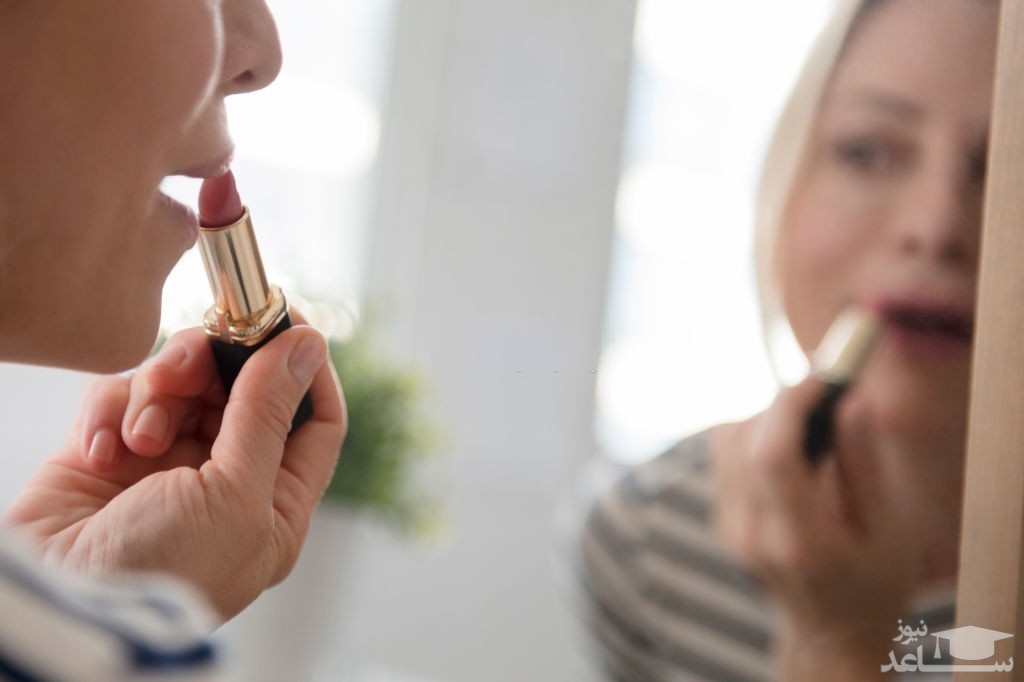 خانمی در حال رژلب زدن