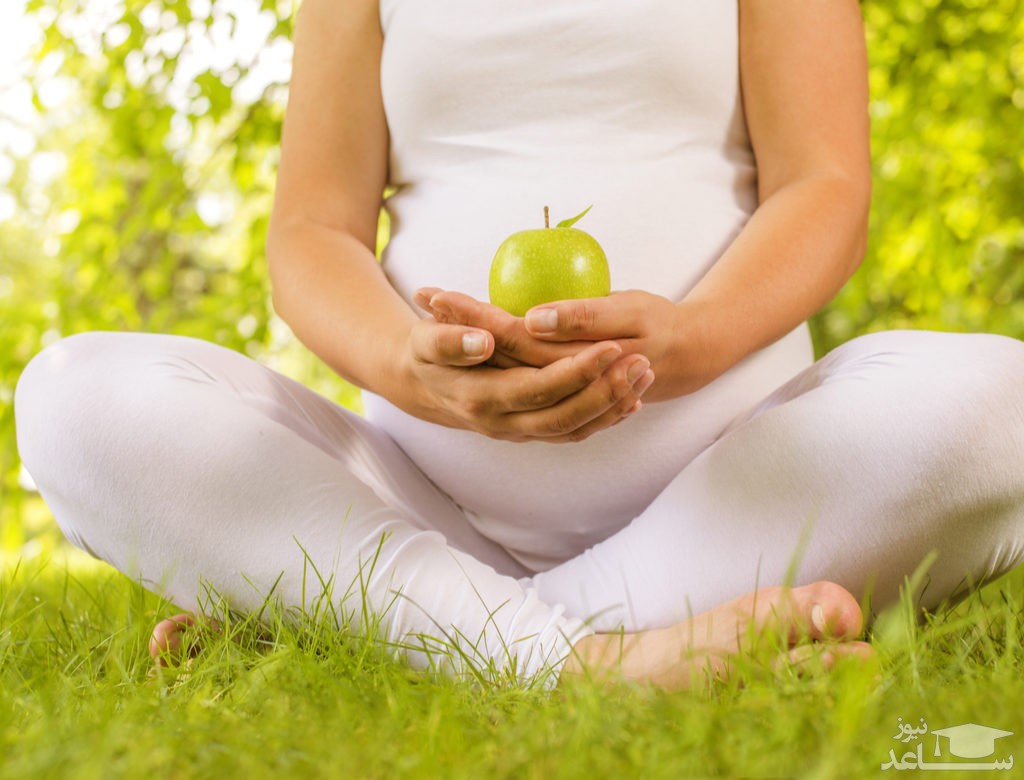 زن باردار سیب بر دست