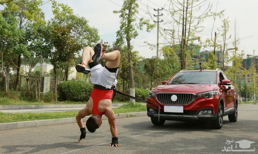 مرد چینی در شهر "سیچوان" با کشیدن 50 متری یک خودرو در حالی که روی دست های خود ایستاده است، رکورد جهانی را شکست./ PA