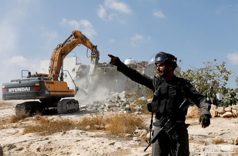 بولدوزر نیروهای اسراییلی در حال تخریب یک خانه فلسطینی در کرانه باختری اشغالی/ رویترز