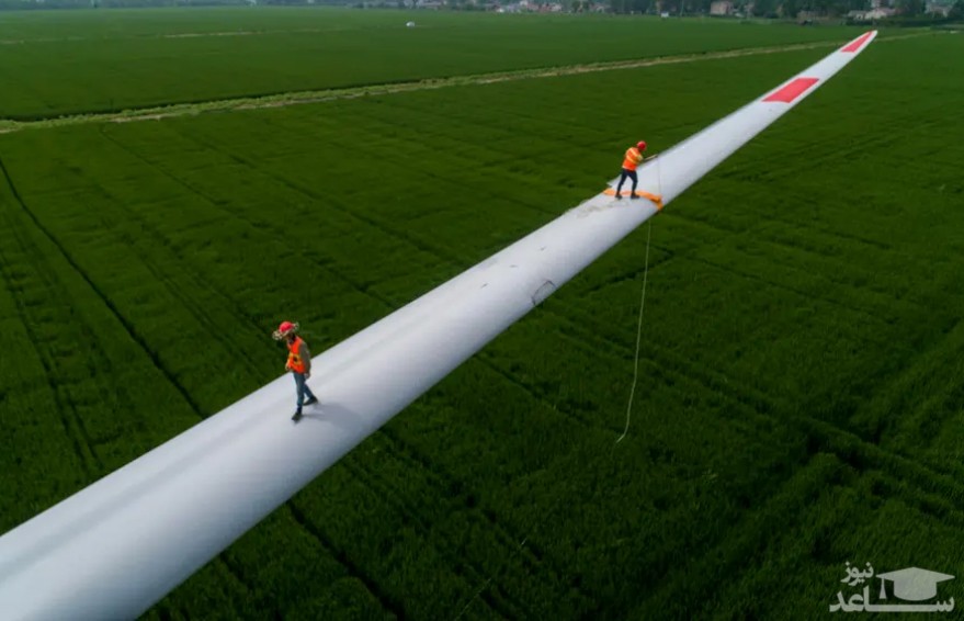 کارگران در حال کار روی پره های یک توربین بادی در چین/ گتی ایمجز
