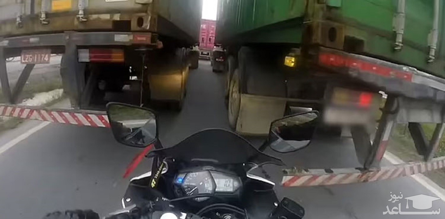 (فیلم) فرار از مرگ موتورسوار حین عبور از میان دو کامیون 