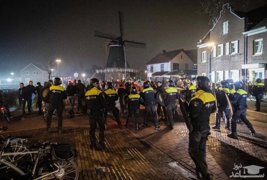 پلیس ضد شورش هلند پس از صدور دستور اضطراری شهردار برای پایان دادن به یک مهمانی غیرقانونی در مقابل شهرداری در روستای "اوریسل" در "دالفسن" هلند، مداخله کرد./ EPA