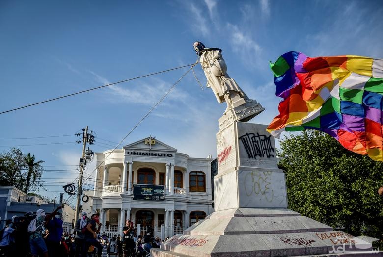 معترضان کلمبیایی در حال پایین کشیدن مجسمه "کریستف کلمب"