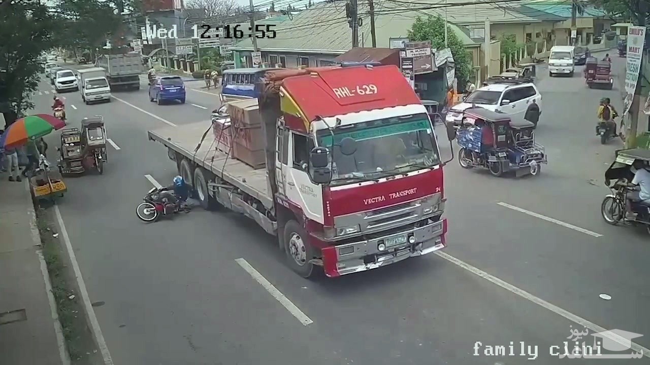 (فیلم) فرار میلیمتری راکب موتور از زیر چرخ‌های کامیون