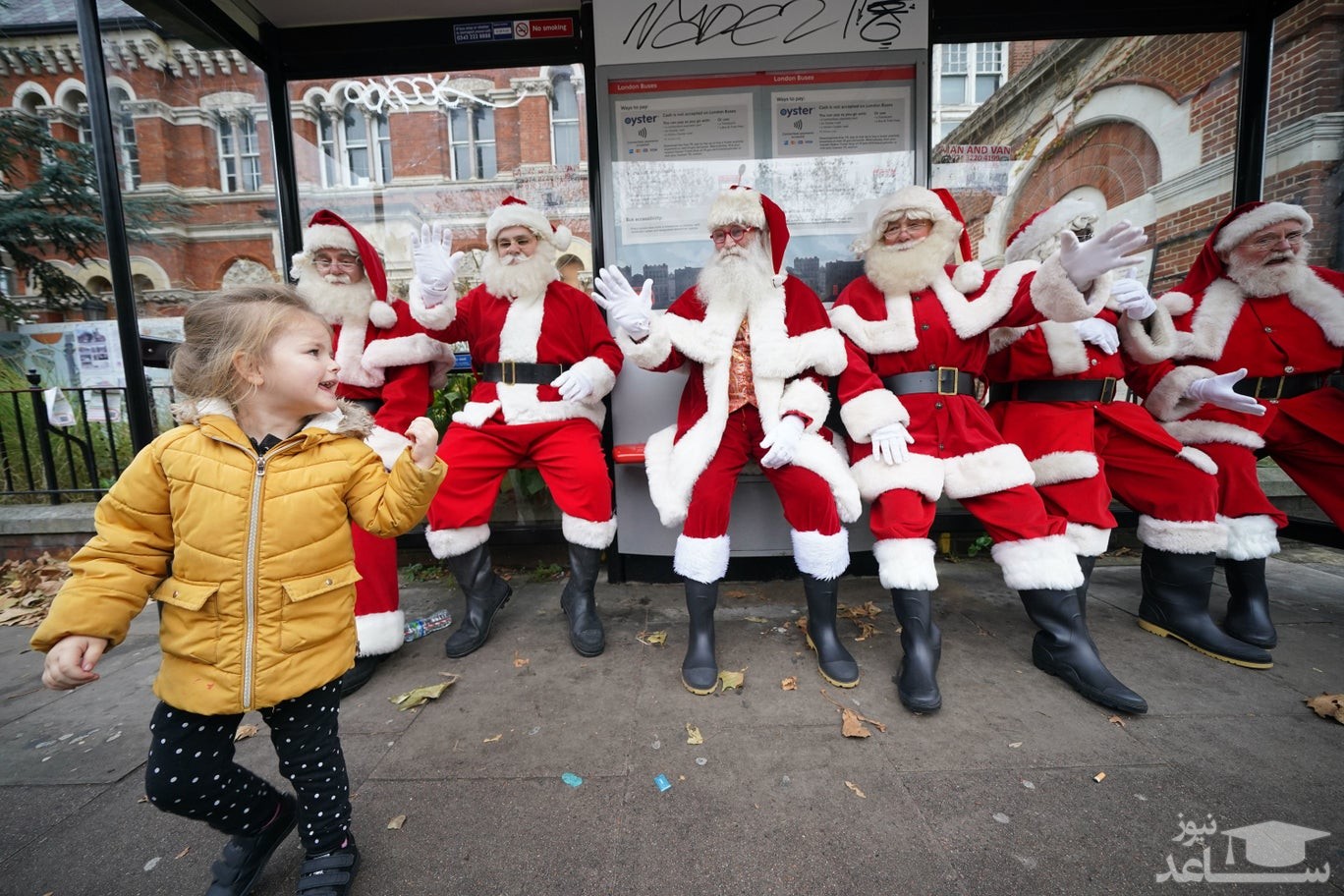 انتظار بابانوئل های انگلیسی برای اتوبوس در ایستگاهی در شهر لندن/ PA