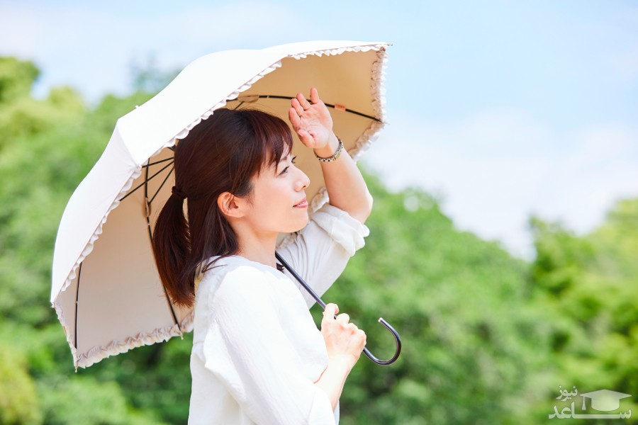 خانمی با چتر در هوای آفتابی