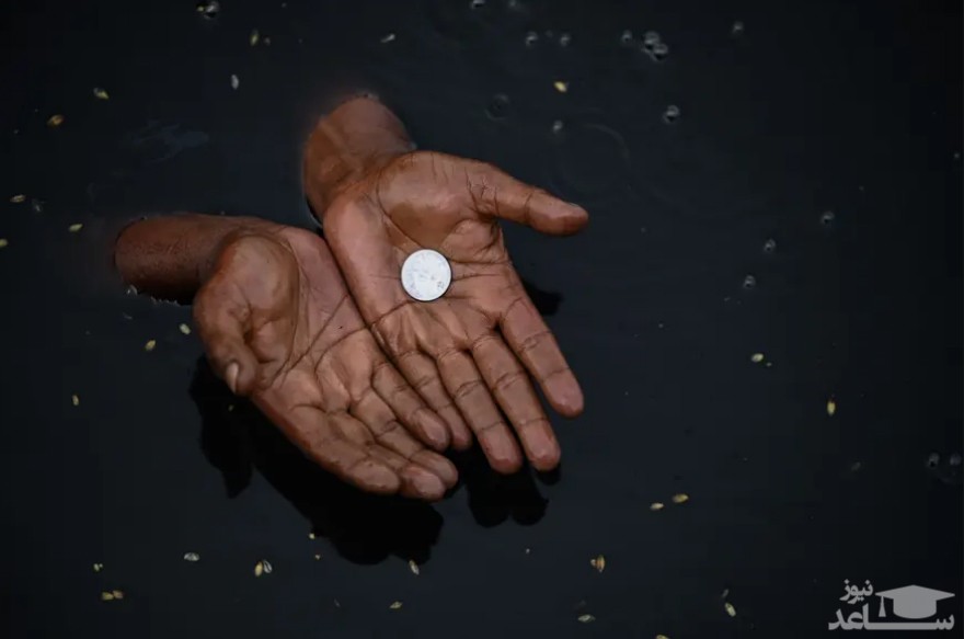 مردی در آب‌های رود "یامونا" در شهر دهلی هند به دنبال پیدا کردن سکه هایی می گردد که هندوها به عنوان نذورات در آب می اندازند./ خبرگزاری فرانسه