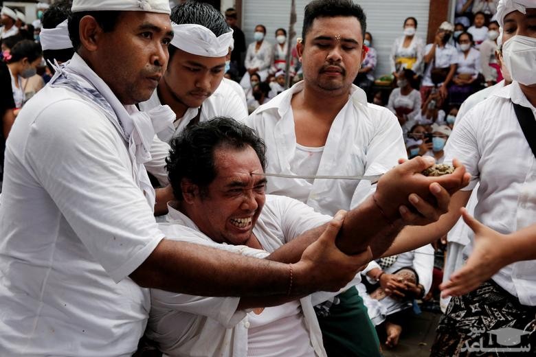 مرد هندو در بالی اندونزی در چارچوب یک مراسم آیینی در حال فرو کردن یک خنجر به پیشانی خود است./ رویترز