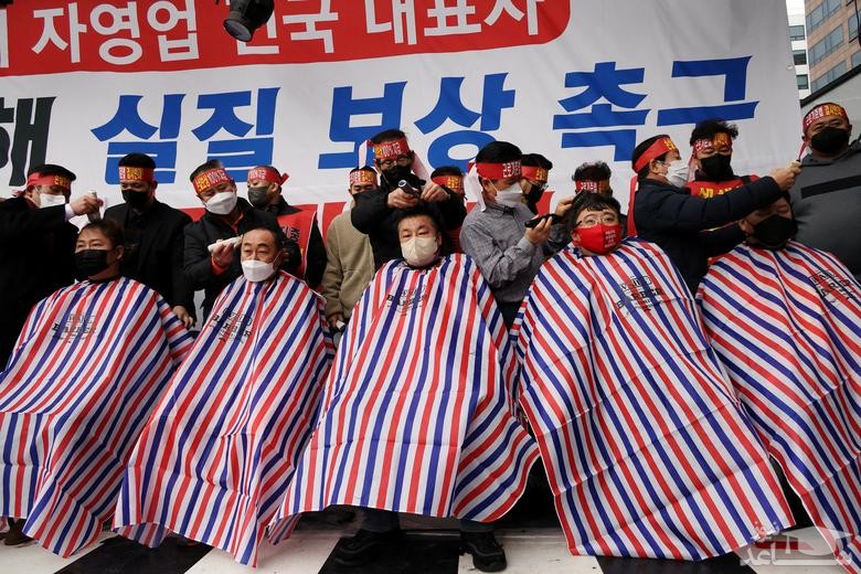 صاحبان مشاغل در شهر سئول کره جنوبی در اعتراض به اعمال محدودیت های کرونایی بر مشاغل، در نزدیکی ساختمان پارلمان کره جنوبی موهای خود را می تراشند./ رویترز