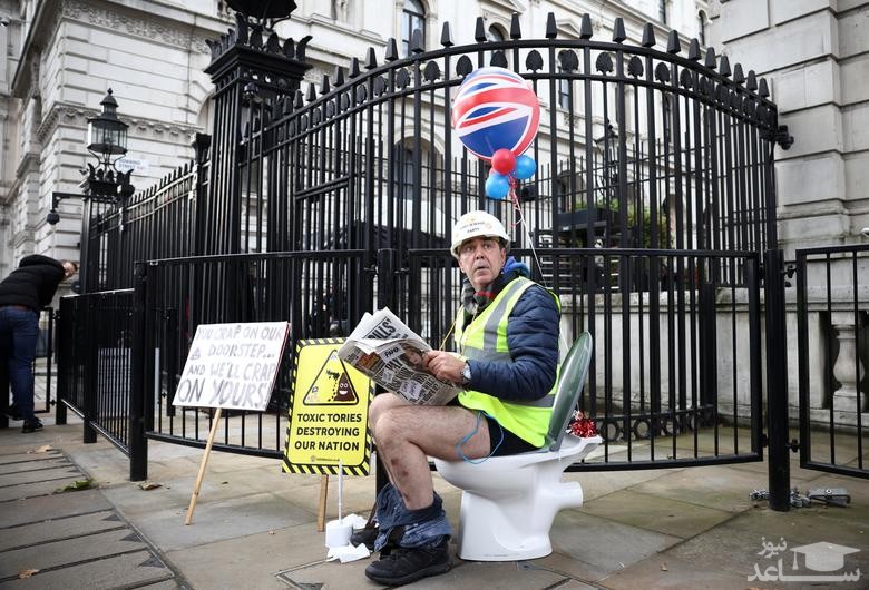 اعتراض توالتی "استیو برِی" فعال بریتانیایی در ورودی خیابان داونینگ لندن به تصویب یک طرح ضد محیط زیستی در مجلس عوام بریتانیا که به شرکت های بریتانیایی اجازه می دهد فاضلاب خود را به رودخانه ها و دریاها بریزند./ رویترز