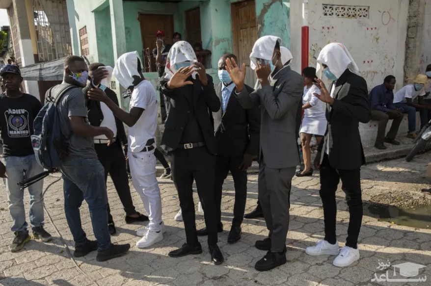 اعضای گروه های تبهکار هاییتی در مراسم تشییع جنازه یکی از سرکردگان خود به منظور پنهان کردن هویت شان صورتشان را پوشانده اند./ آسوشیتدپرس