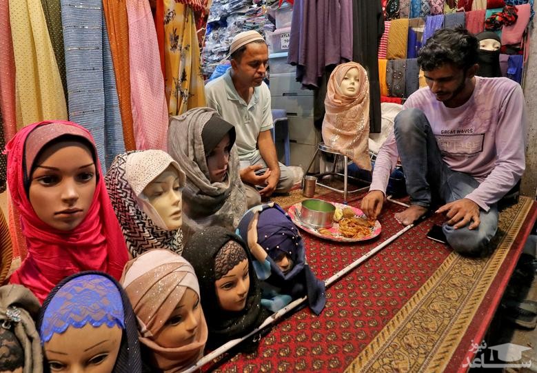 افطاری در مغازه ای شال فروشی در بازاری در شهر بمبئی هند/ رویترز