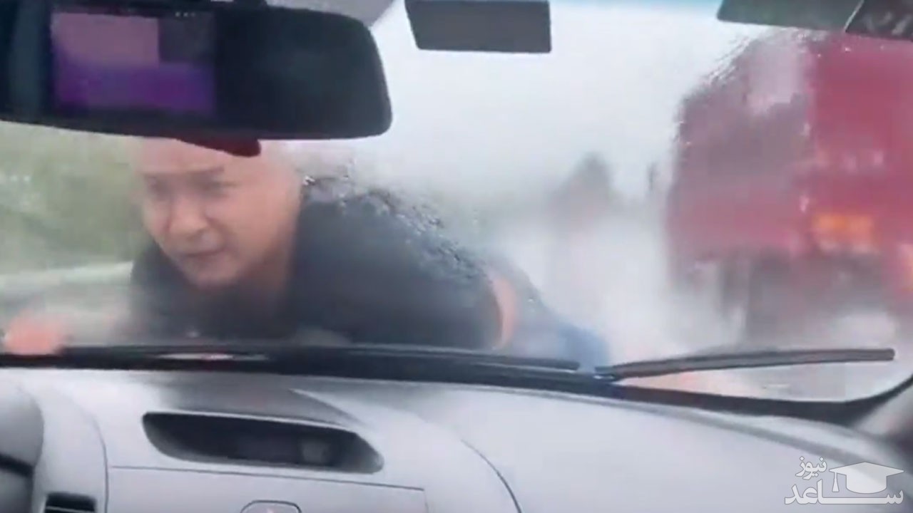 (فیلم) دراز کشیدن یک مرد روی کاپوت خودرو در بزرگراه