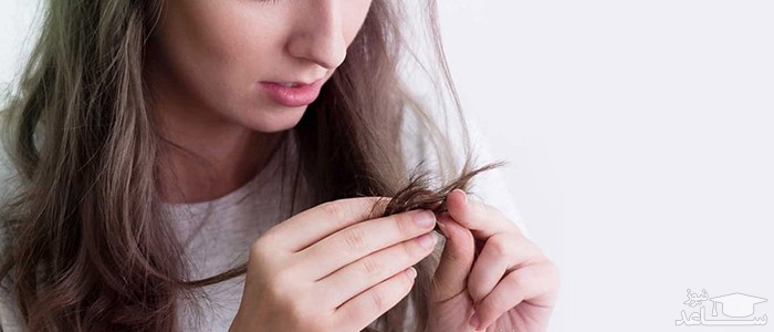 خانمی در حال نگاه کردن به نوک موهایش