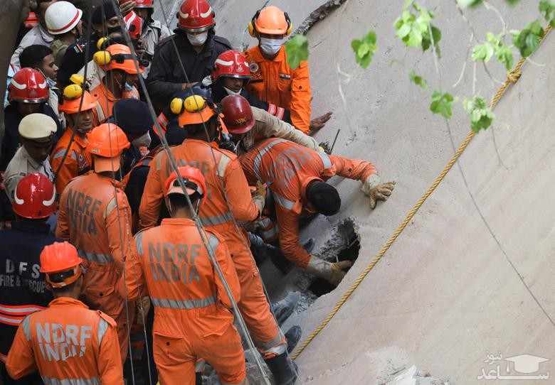 امدادگران در حال جستجوی افراد زیر آوار در ساختمانی فروریخته در شهر دهلی هند/ رویترز