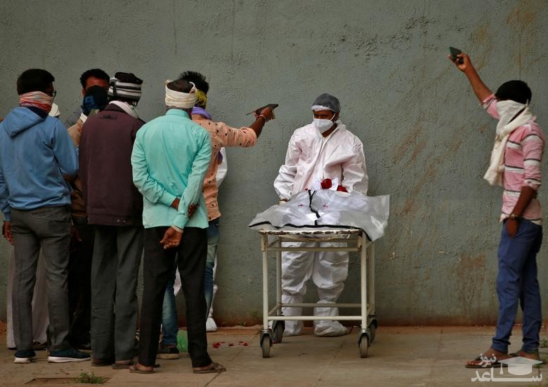خانواده های بیماران فوت شده کرونایی از جسد متوفی شان در بیمارستانی در شهر احمدآباد هند عکس می گیرند./ رویترز