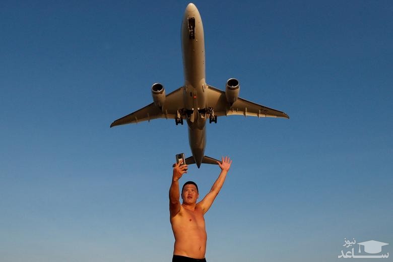 گردشگر روسی در حال سلفی گرفتن با هواپیمای مسافربری در حال فرود به فرودگاه بین المللی جزیره پوکت تایلند/ رویترز