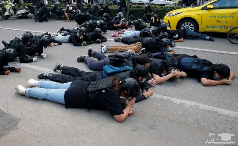 پناه گرفتن معترضان تایلندی در برابر شلیک گلوله های پلاستیکی از سوی پلیس در جریان یک تظاهرات ضددولتی در شهر بانکوک/ رویترز