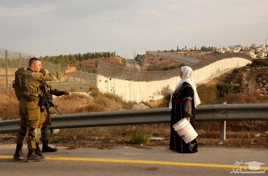 عبور یک زن فلسطینی از ایست بازرسی نیروهای اسراییل برای رفتن به باغ زیتون خود در کرانه باختری/ خبرگزاری فرانسه