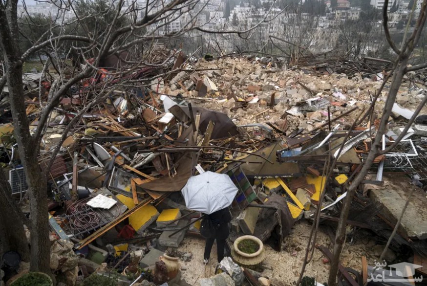 زنی به ویرانه های یک خانه فلسطینی که توسط شهرداری شهر قدس در محله "شیخ جراح" تخریب شده است نگاه می کند. پلیس اسراییل ساکنان فلسطینی این محله را بیرون کرده و ساختمان آنها را تخریب می کند./ آسوشیتدپرس
