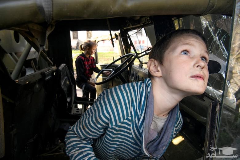 کودکان در روستایی در اوکراین داخل یک خودروی نظامی منهدم شده روسی شده اند./ رویترز