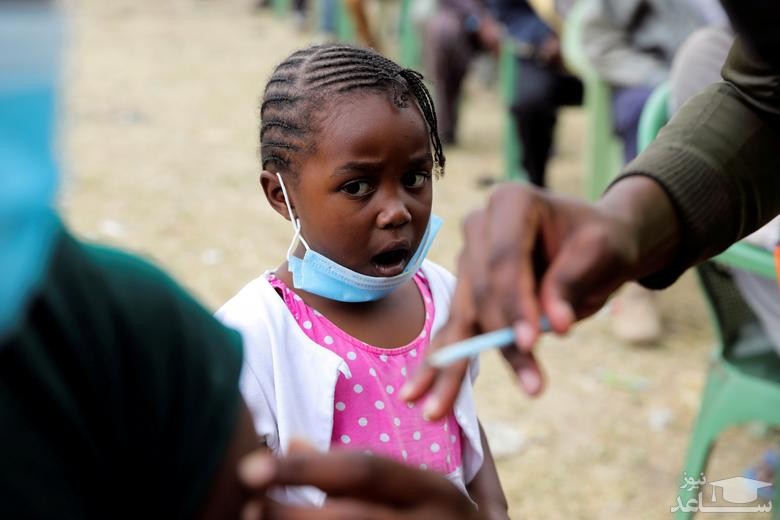 دخنر کنیایی در حال تماشای واکسن زدن پدرش