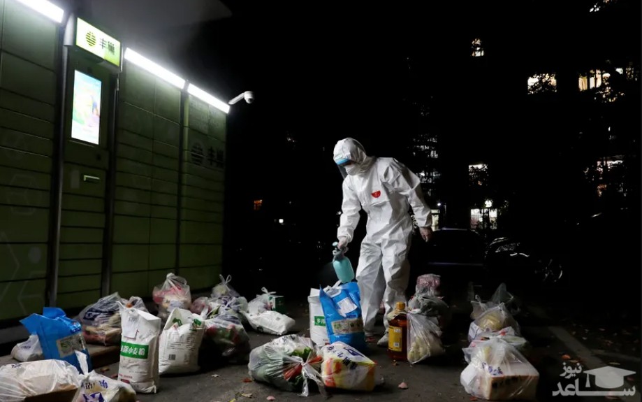 یک نیروی داوطلب در شهر قرنطینه شده شانگهای چین در حال ضدعفونی کردن محموله های غذایی توزیعی بین خانه ها/ شینهوا