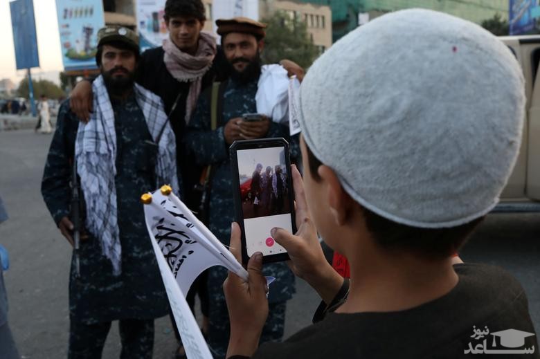 نوجوان حامی طالبان در حال عکس گرفتن از شبه نظامیان طالبان 