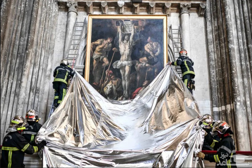 آتش نشانان فرانسوی در حین یک مانور ایمنی با هدف حفظ آثار هنری در کلیسای جامع "سنت اندرو" شهر "بوردو" با کشیدن یک پارچه از یک نقاشی محافظت می کنند./ SIPA