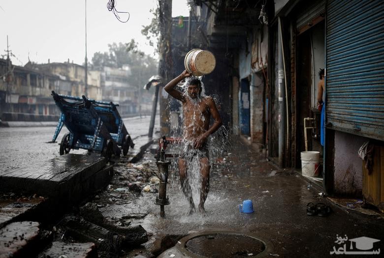 حمام کردن در یک بازار محلی در شهر دهلی هند/ رویترز