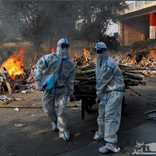 (عکس) کارگر خسته و بی رمق هندی در محل سوزاندن اجساد کرونایی